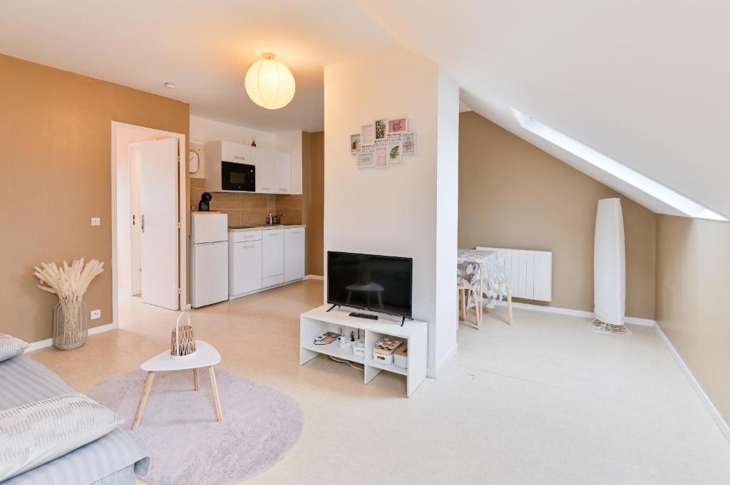 a living room with a flat screen tv and a staircase at Cosy app near sea in Cabourg