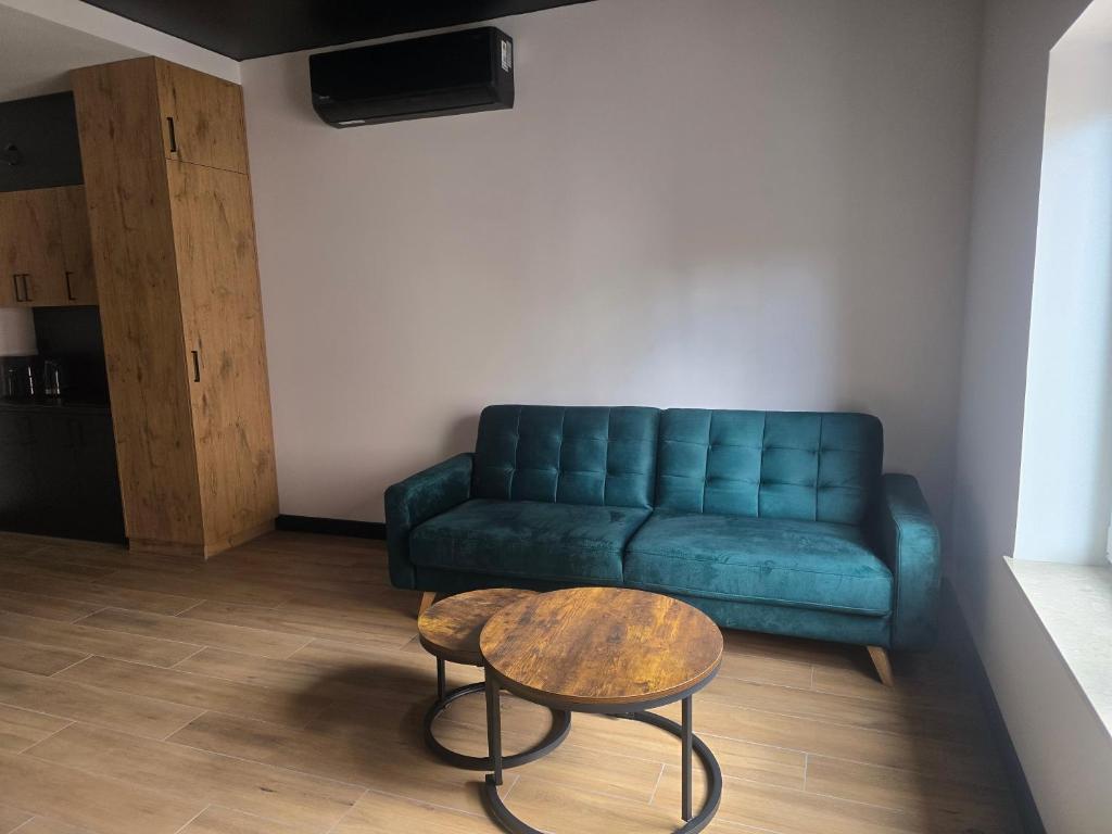 a living room with a blue couch and a table at TRIO HoSteL in Hajnówka