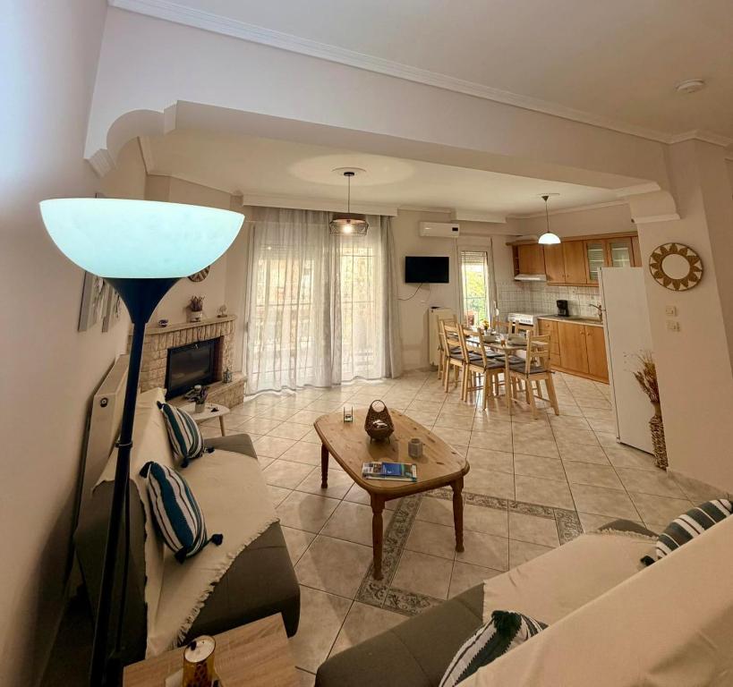 a living room with a couch and a table at Summer Comfort Apartment in Nea Kallikrateia