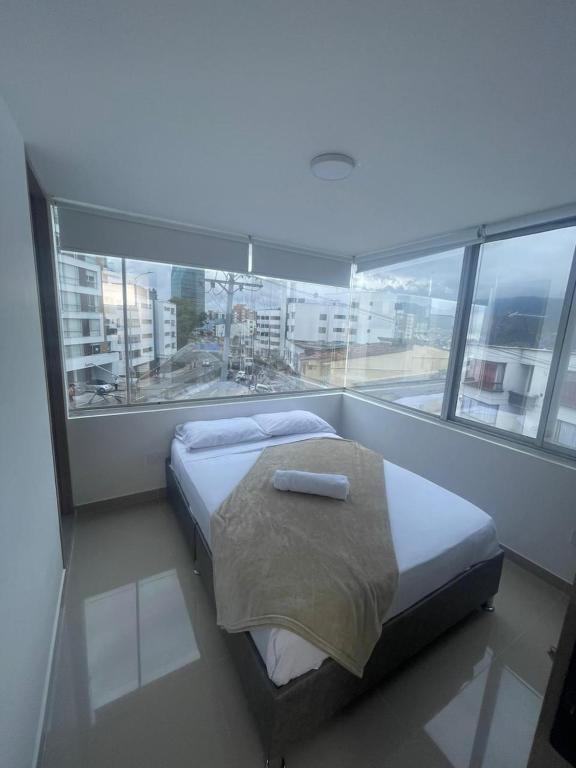 a bedroom with a bed and a large window at Hotel Portal Del Cerro Manizales in Manizales