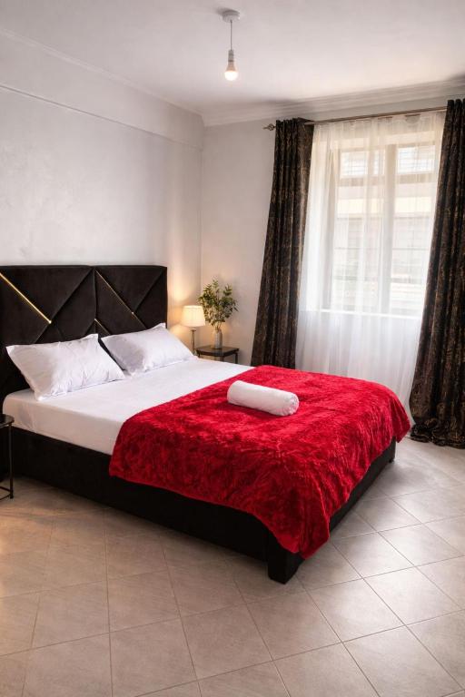 a bedroom with a large bed with a red blanket at Serenity suites in Nairobi
