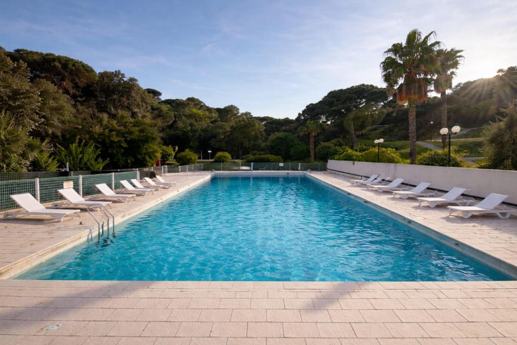 a swimming pool with chaise lounge chairs and a swimming pool at Charmant studio avec piscine 4 personnes in Fréjus