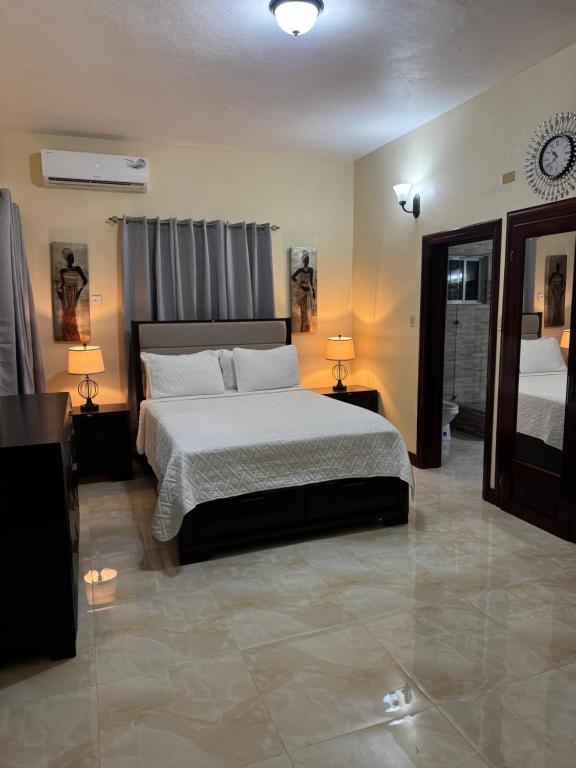 a bedroom with a bed and two lamps and a clock at Trelawnys Bliss Escape in Spring Rises