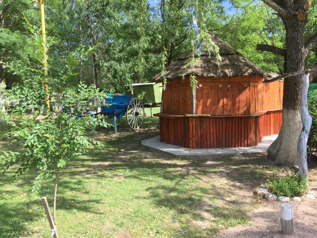 Cabaña de madera pequeña con mesa azul y carro en Hosteria Renca en 