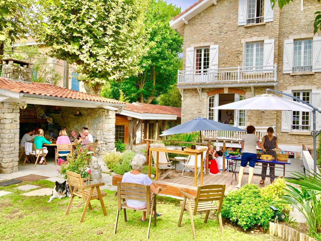 a group of people sitting in the yard of a house at Maisonnette Cosy Villa Ajna in Bayonne