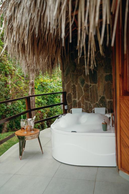 a bath tub in a room with a table at Zirwa Hotel Boutique - Dentro del Parque Tayrona in El Zaino