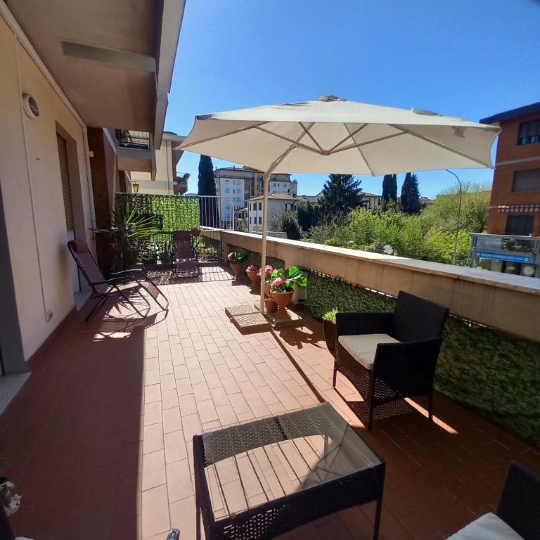 a patio with chairs and an umbrella on a balcony at Casa Manzoni 45 in Scandicci