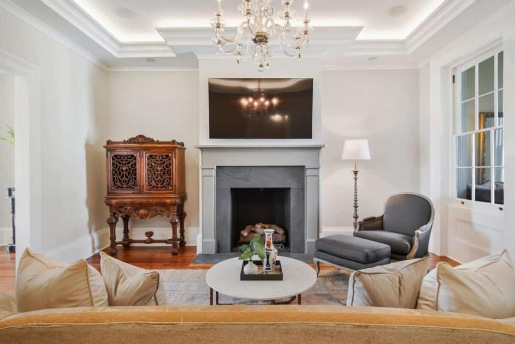 a living room with a couch and a fireplace at Historic CBD Townhomes with Courtyard in New Orleans