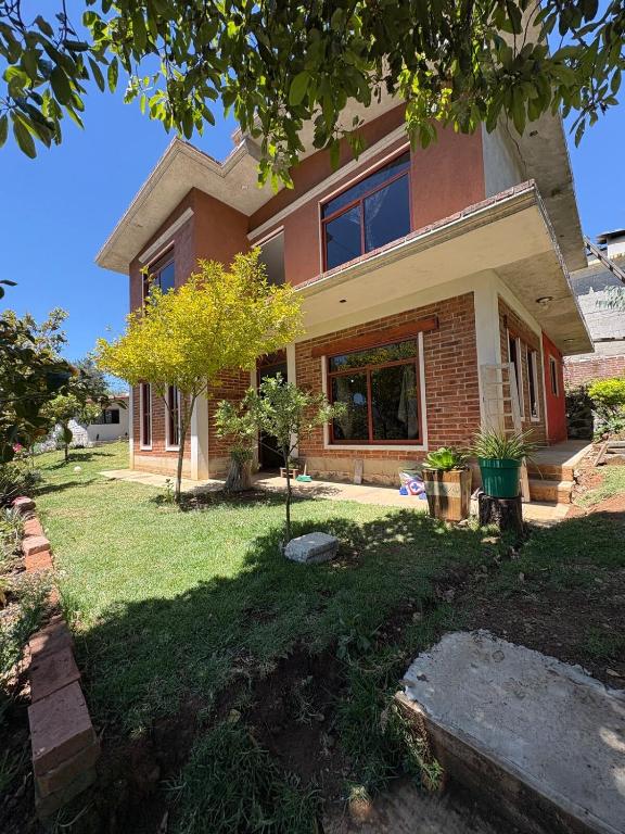a house with a tree in front of it at Brisa Campestre in Tomatlán