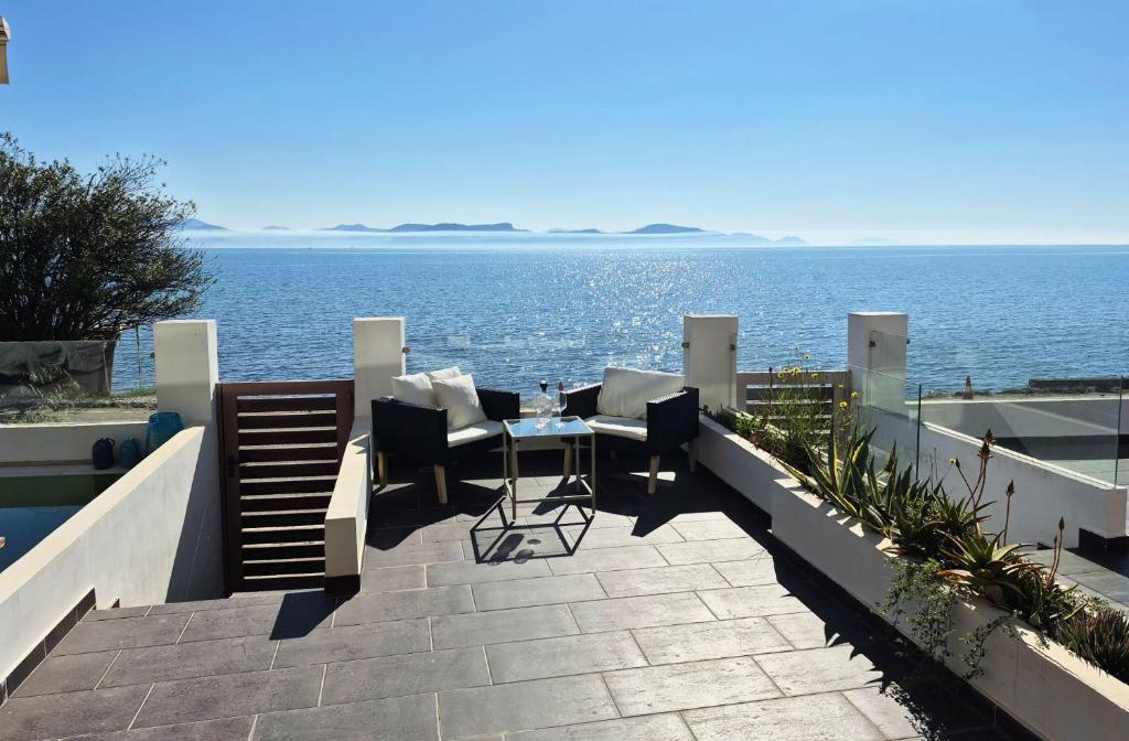 a patio with a table and chairs overlooking the ocean at Blue Bay Suites in Myloi