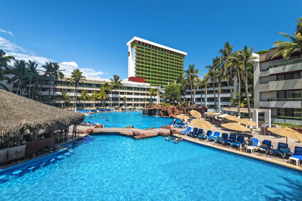 una piscina con sillas y un complejo en El Cid El Moro Beach en Mazatlán