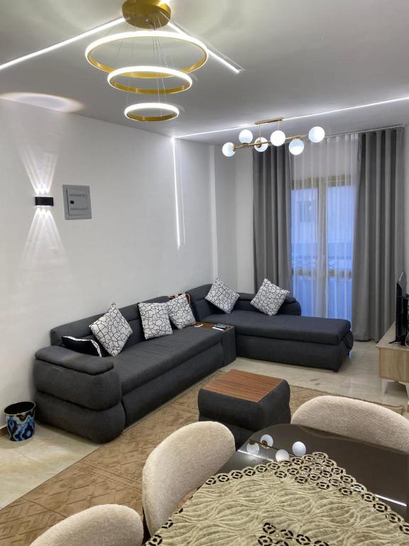a living room with a black couch and a table at سكن فندقى باكتوبر in Al Kawāmil Qiblī