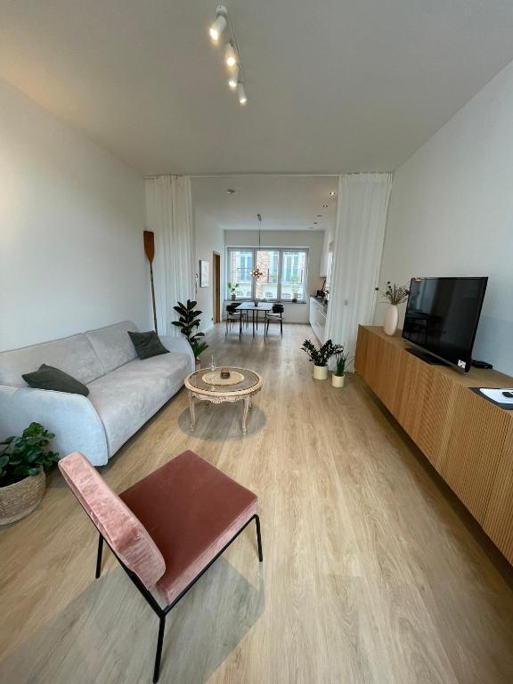 a living room with a couch and a table at Cabine Congé sfeervol appartement dichtbij zee in Ostend