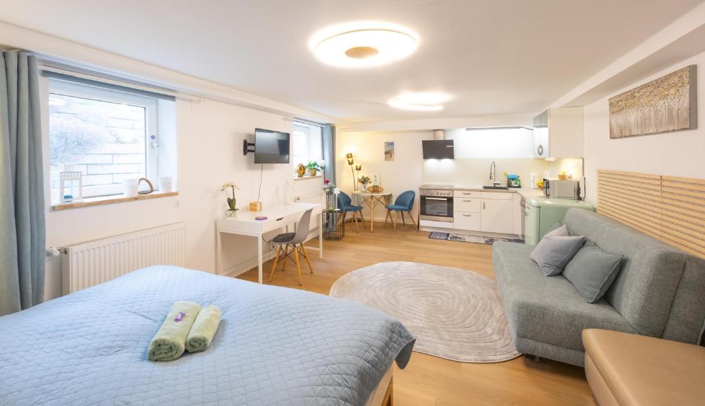 a bedroom with a bed and a couch and a kitchen at Ruhig Top mod Studio Appartement,privater Eingang in Oberhaching