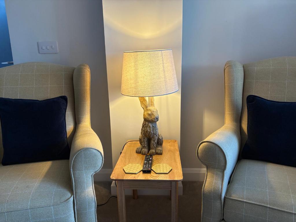 a lamp sitting on a table next to two chairs at The Nest - Worcester in Worcester