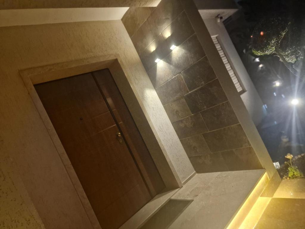 a door in a room with a wall with lights at Villa janna in Sukrah
