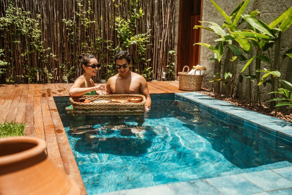 a man and a woman sitting in a swimming pool at Reserva Mazu in São Miguel dos Milagres