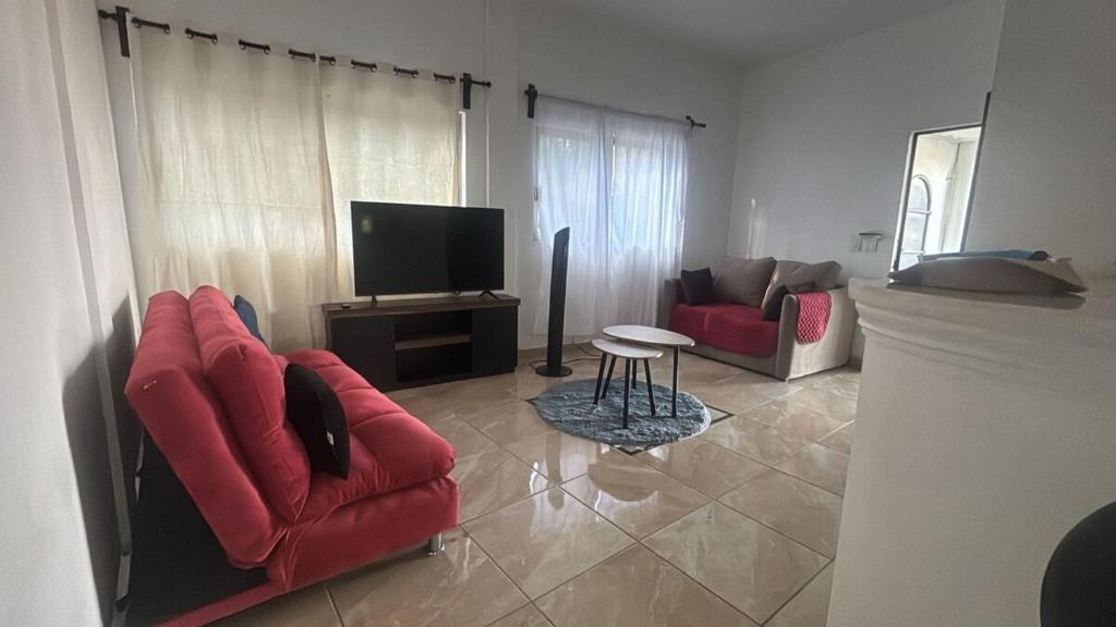 a living room with red chairs and a flat screen tv at The best sunrise in Salina Cruz