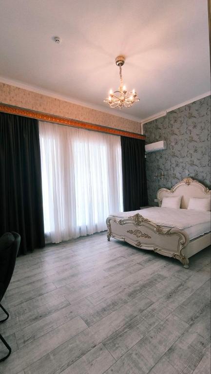 ein Schlafzimmer mit einem großen Bett und einem Kronleuchter in der Unterkunft Siena Hotel in Odessa