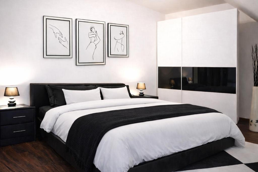 a bedroom with a large bed with three drawings on the wall at Holiday House Jana in Muráň