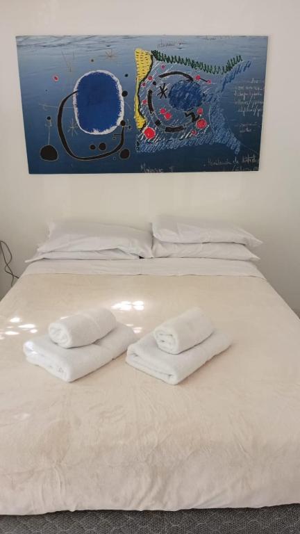 a bed with white towels on top of it at Departamento centro Gral Roca in General Roca