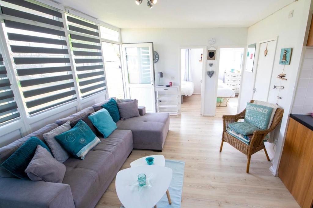 a living room with a couch and a table at The Retreat Camber in Camber