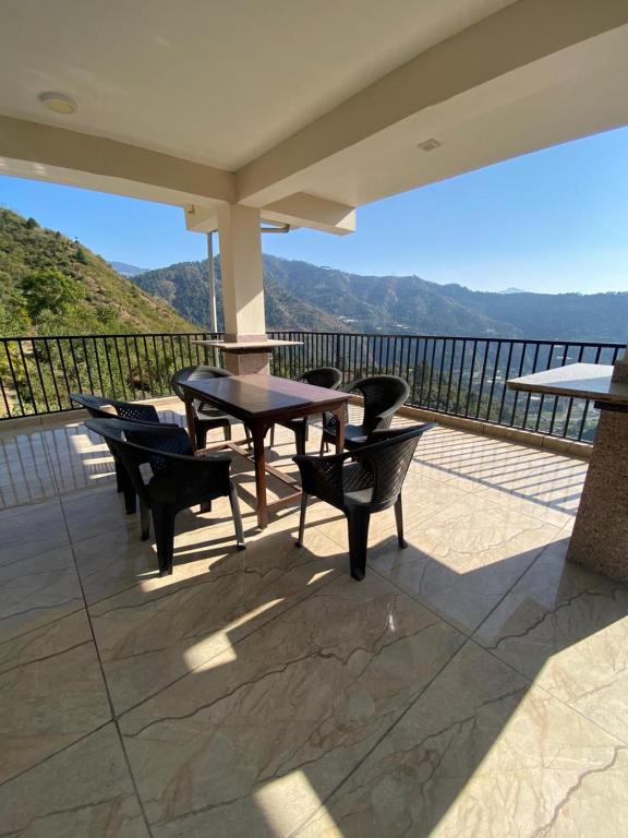 a patio with a table and chairs on a balcony at Rivervalley View Homestay in Kandāghāt