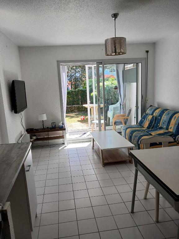 a living room with a couch and a table at Pointe Saint-Jacques - L'entre deux vagues in Sarzeau