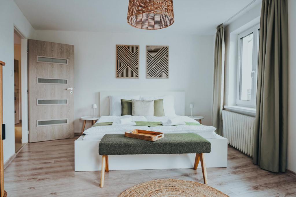 a white bedroom with a bed and a table at Napajedla in Znojmo