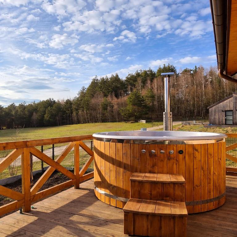 a wooden barrel sitting on top of a deck at Domek w Skolitach in Skolity