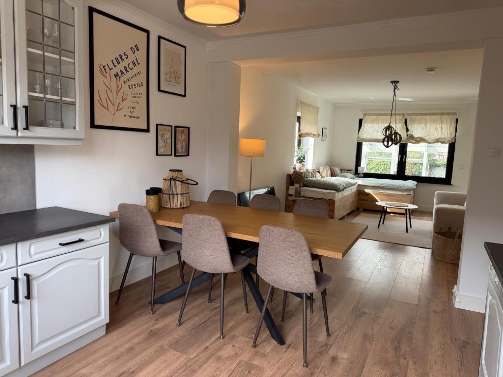 a kitchen and living room with a wooden table and chairs at WohlfühlWerk L7 in Mechernich