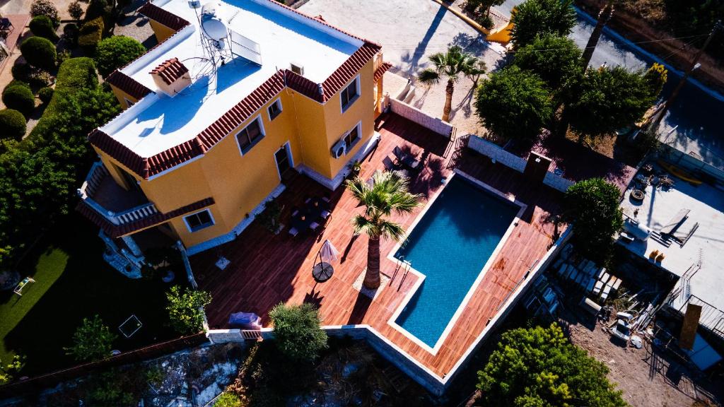 an overhead view of a large yellow house with a swimming pool at Casa Alba Modern Boho Villa with private Pool near to Sea, Paphos in Peyia