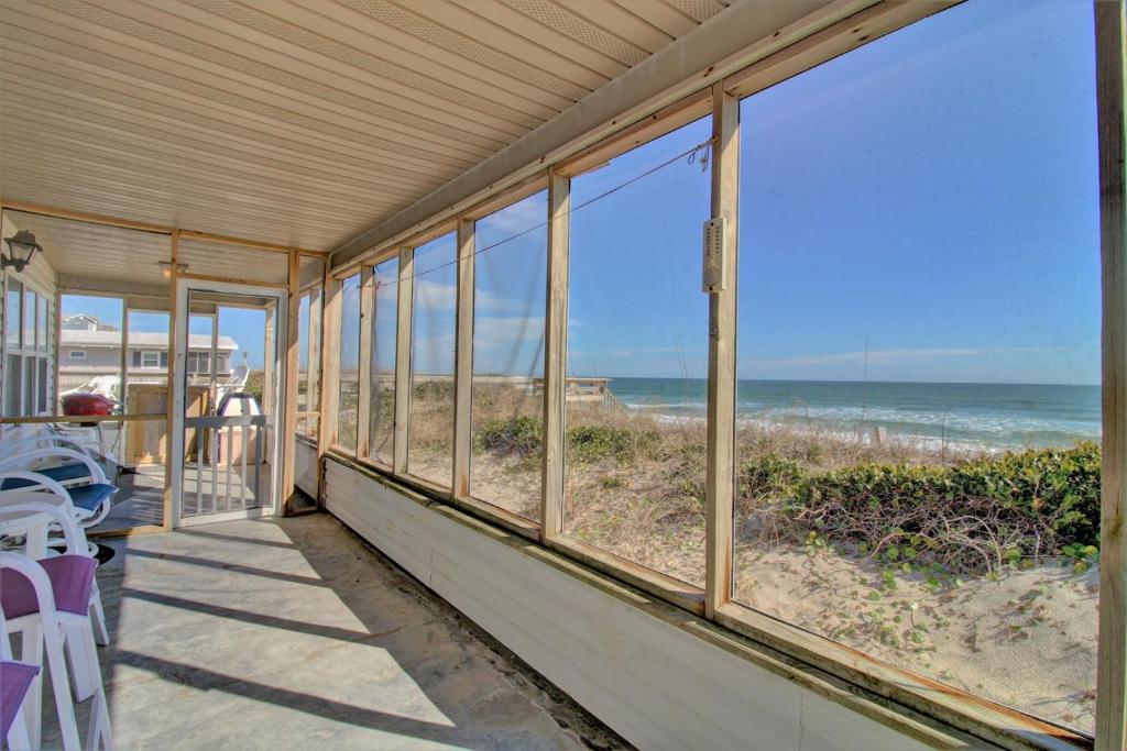 a screened porch with a view of the beach at Wave To Cool in Surf City