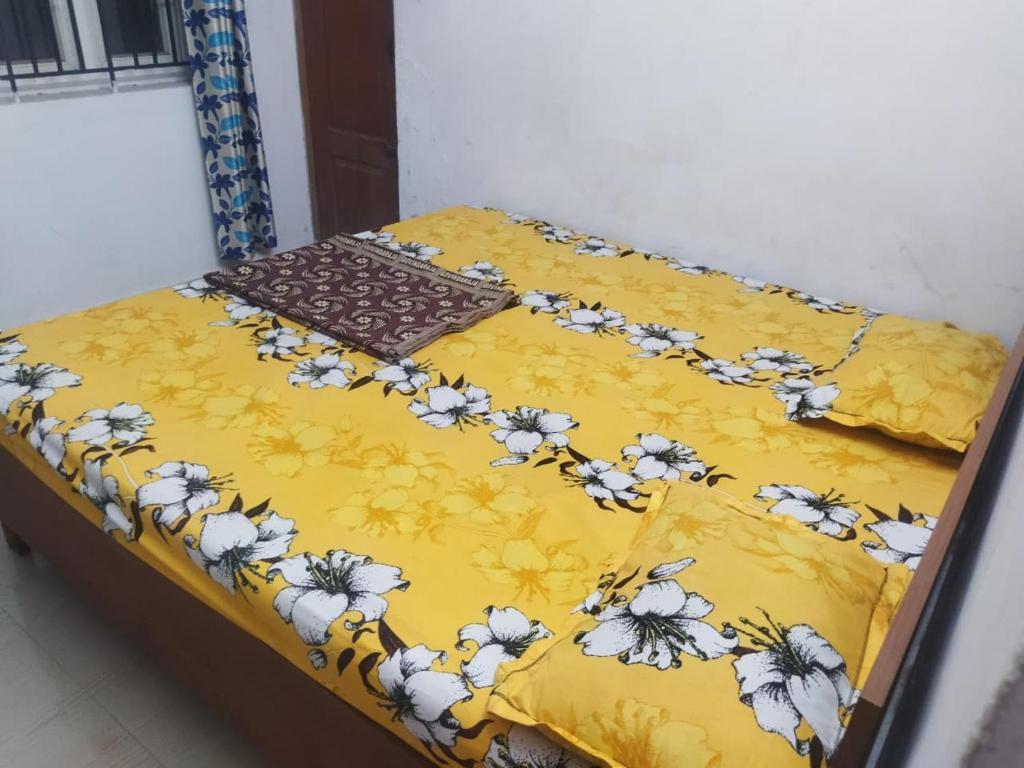a yellow comforter with white flowers on it at Nomad in Coimbatore