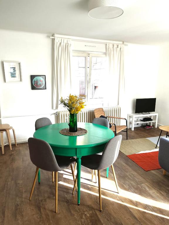 a dining room with a green table and chairs at Au perron avec garage et balcon à Ribeauville in Ribeauvillé
