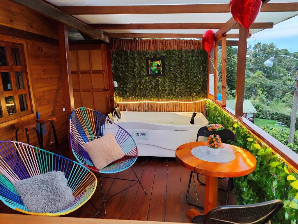a balcony with a tub and chairs and a table at Glamping STELAR VILLA EL EDEN in Cali