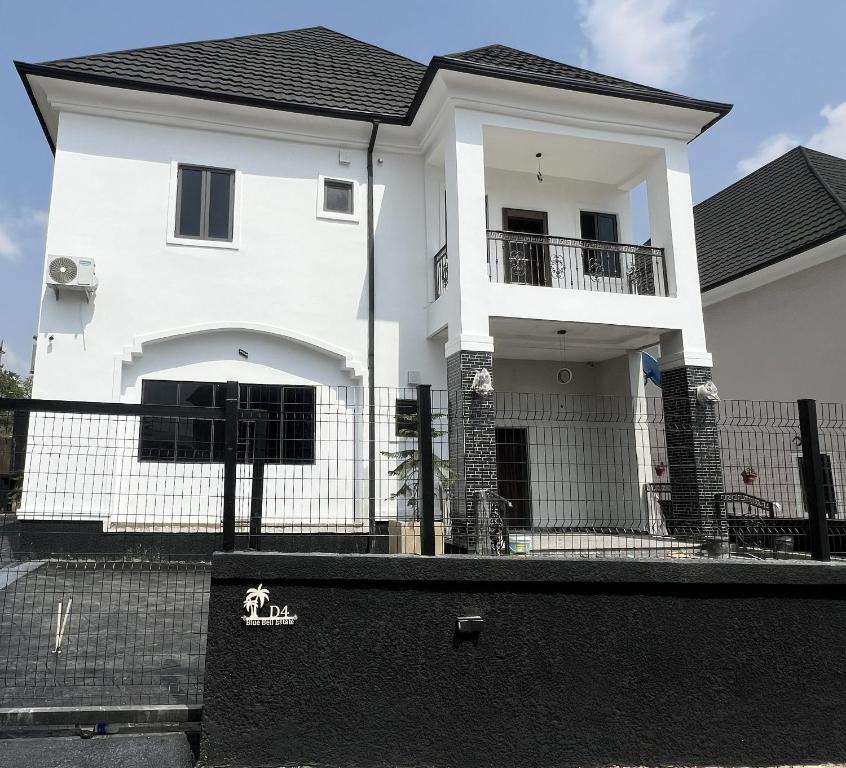 a white house with a fence in front of it at TWR Abuja Partner #Blessing in Abuja