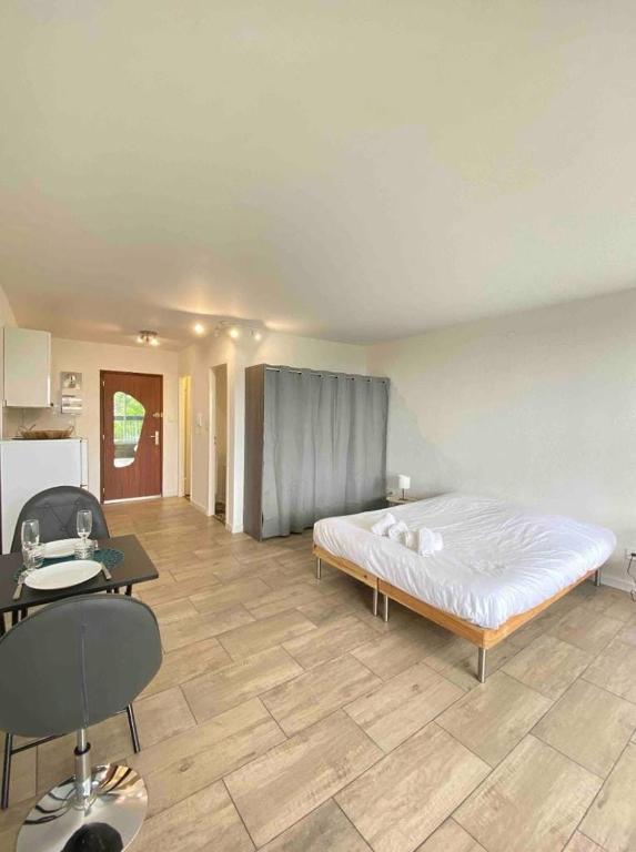 a bedroom with a bed and a table and a kitchen at - Le Belvédère - in Turckheim
