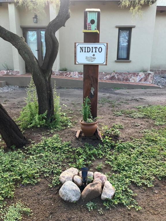 a sign for a nido sign next to a tree at Casa Nidito San Javier in San Javier