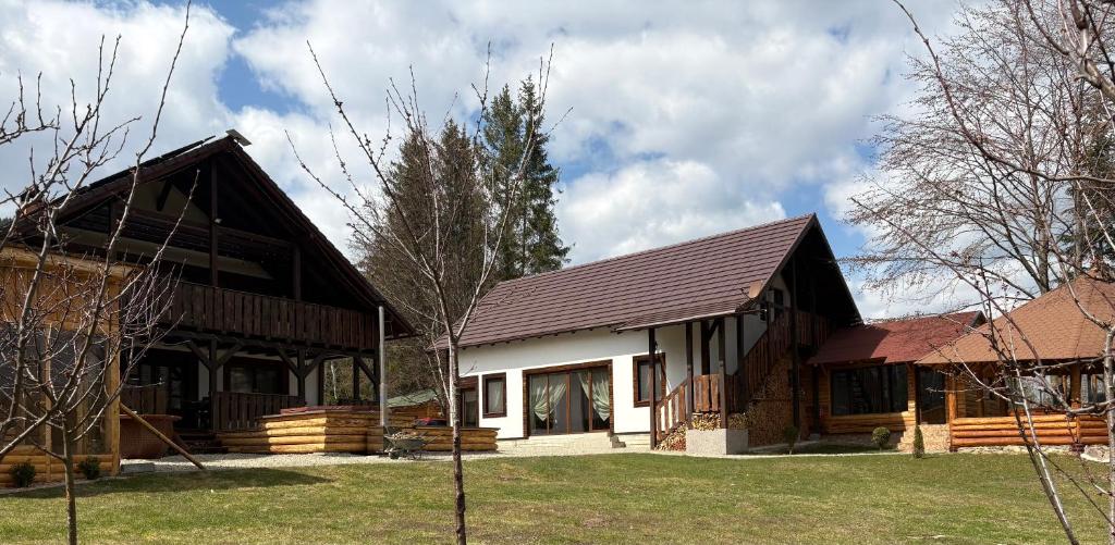 a home with a gambrel roof and a white at Hanna's Hidden Haven in Harghita-Băi