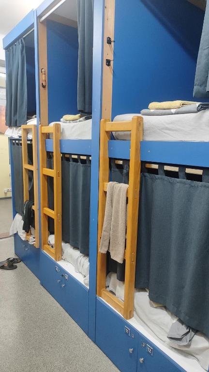 two bunk beds in a blue room with towels at Лидер Хаус хостел in Varna City