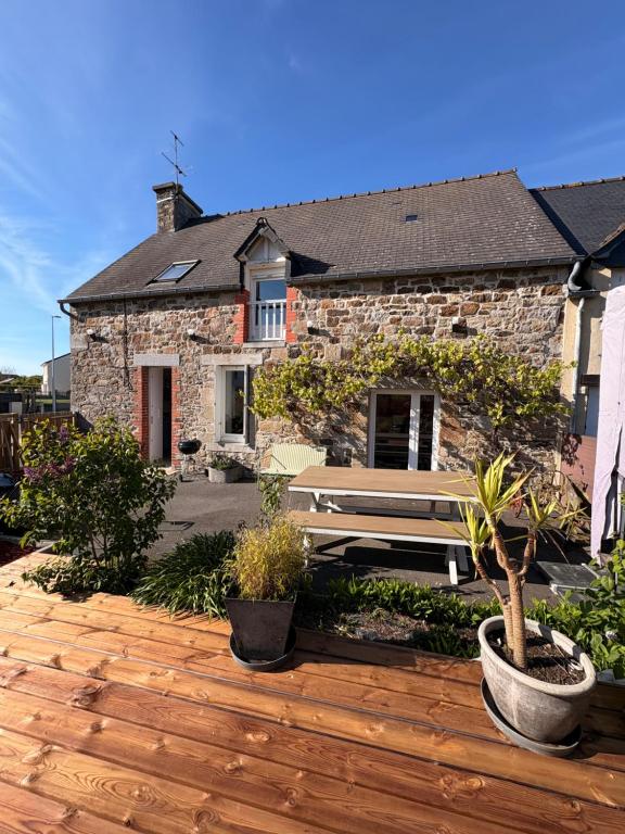 a house with a wooden deck in front of it at L'abri côtier du Vivier in Le Vivier-sur-Mer