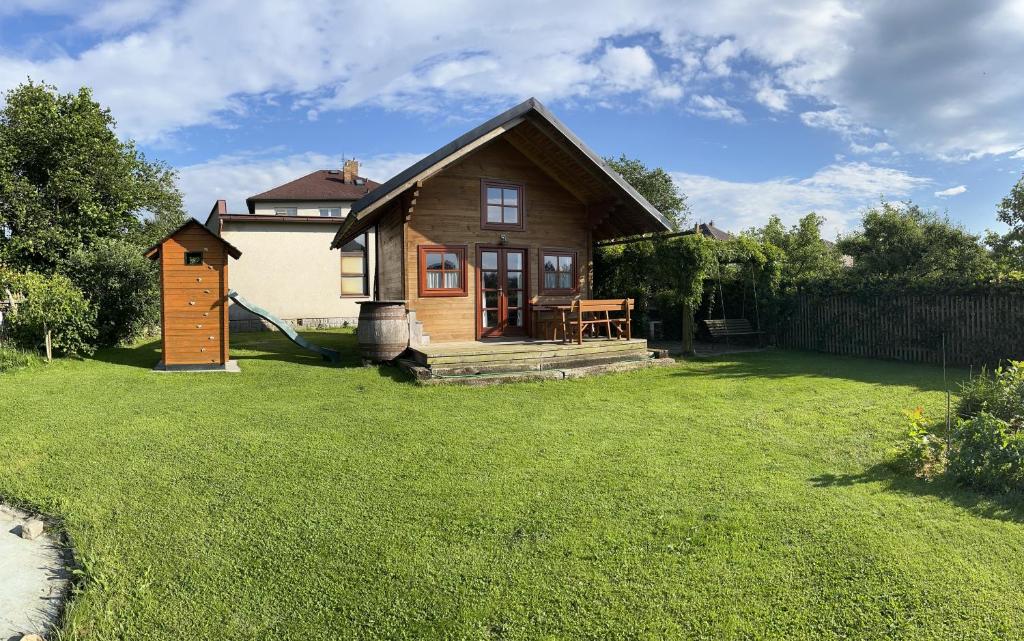 a small house in a yard with a green lawn at Srub u Hadiny in Pelhřimov