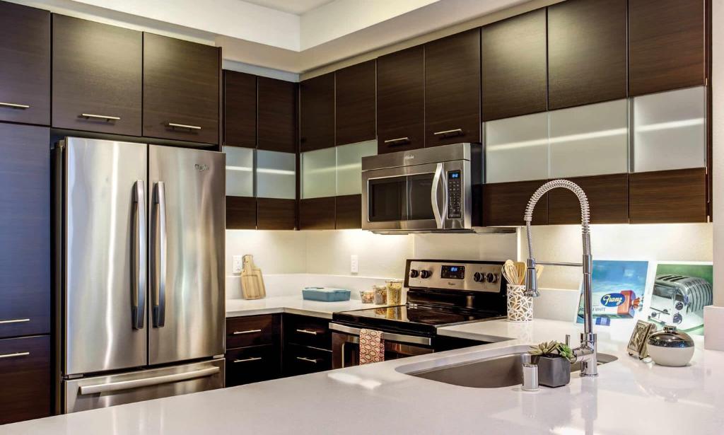 a kitchen with wooden cabinets and a stainless steel refrigerator at Madera in Mountain View