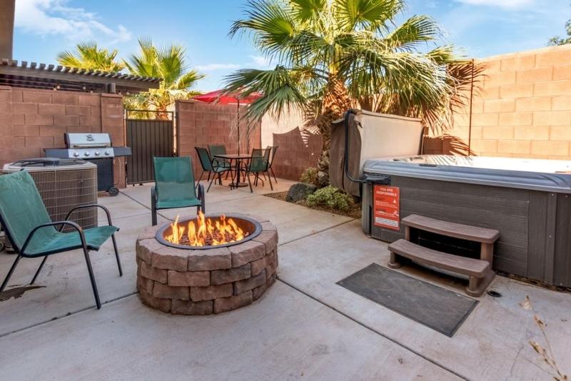 a patio with a fire pit and chairs and a grill at Townhome Near Zion with Hot Tub & Pool in Washington