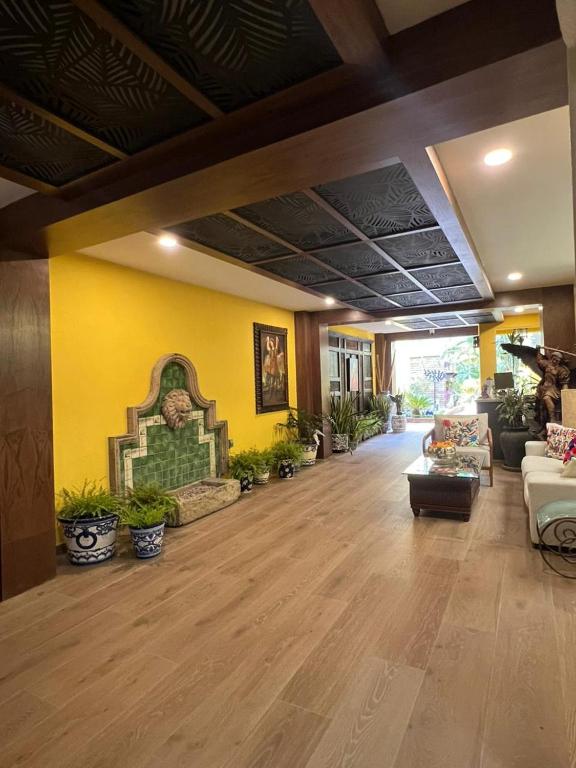 a living room with yellow walls and potted plants at El Encanto Inn & Suites in San José del Cabo