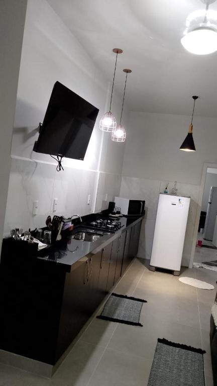 a kitchen with a black counter top and a refrigerator at N 40 - Central com 2 quartos, ar condicionado e garagem in Cascavel