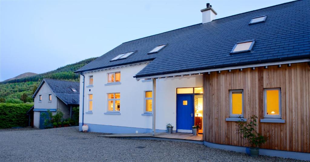 une maison blanche avec une porte bleue dans l'établissement Cherryhill Lodge, à Newcastle