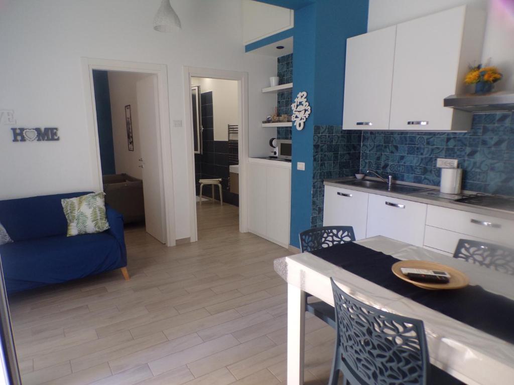 a kitchen and a living room with a table and chairs at Alloggio Turistico Mare Blu Gaeta in Gaeta