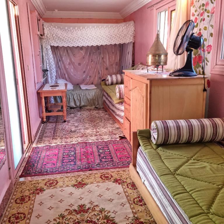 a bedroom with a bed and a couch and a table at Momo's villa 2nd room in Aït Ourir
